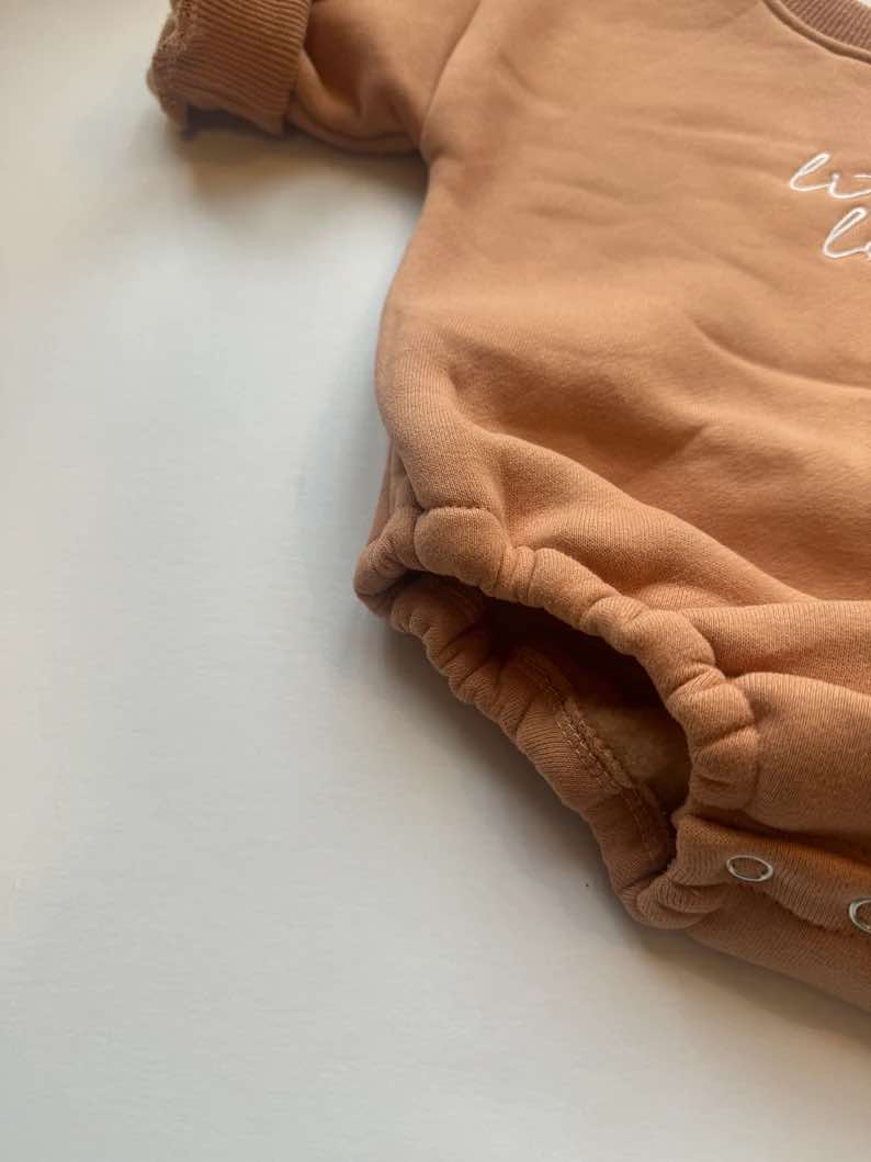 Gender-neutral  burnt orange rompers for babies, soft and cozy for winter.