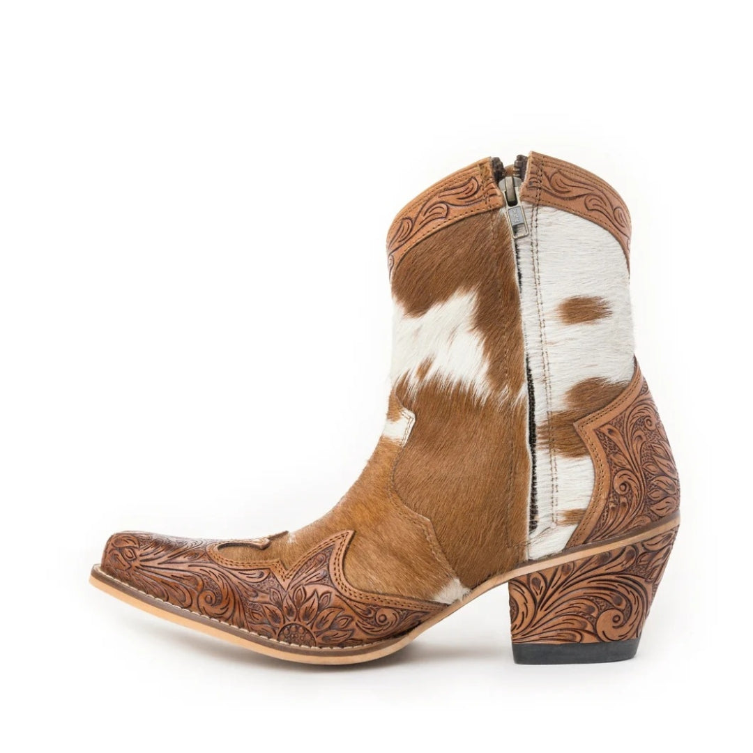 Side view of a Georgia ankle boot showing tan and white cowhide, a side zip and floral-tooled leather toe and heel.