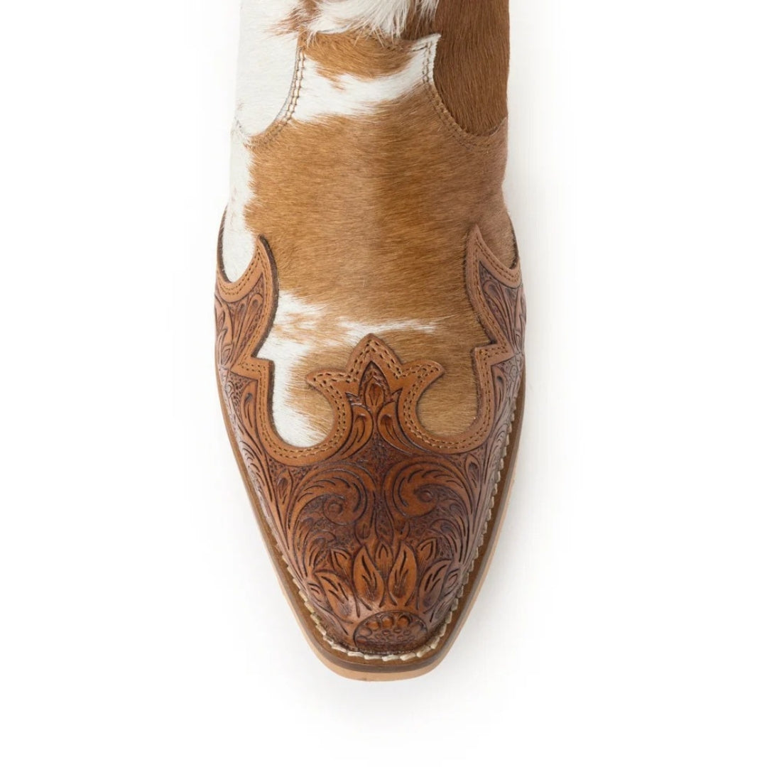 Close-up of the Georgia boot’s snip toe, showing sunflower and scroll tooling in tan leather over natural cowhide.