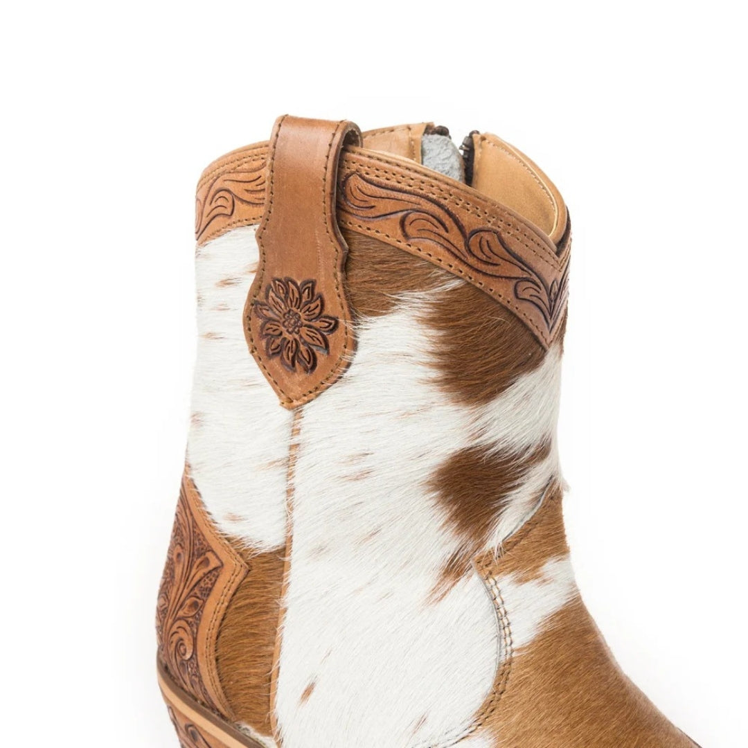 Close-up of the Georgia boot’s tan and white hair-on hide, tooled leather top trim and floral leather pull tab.