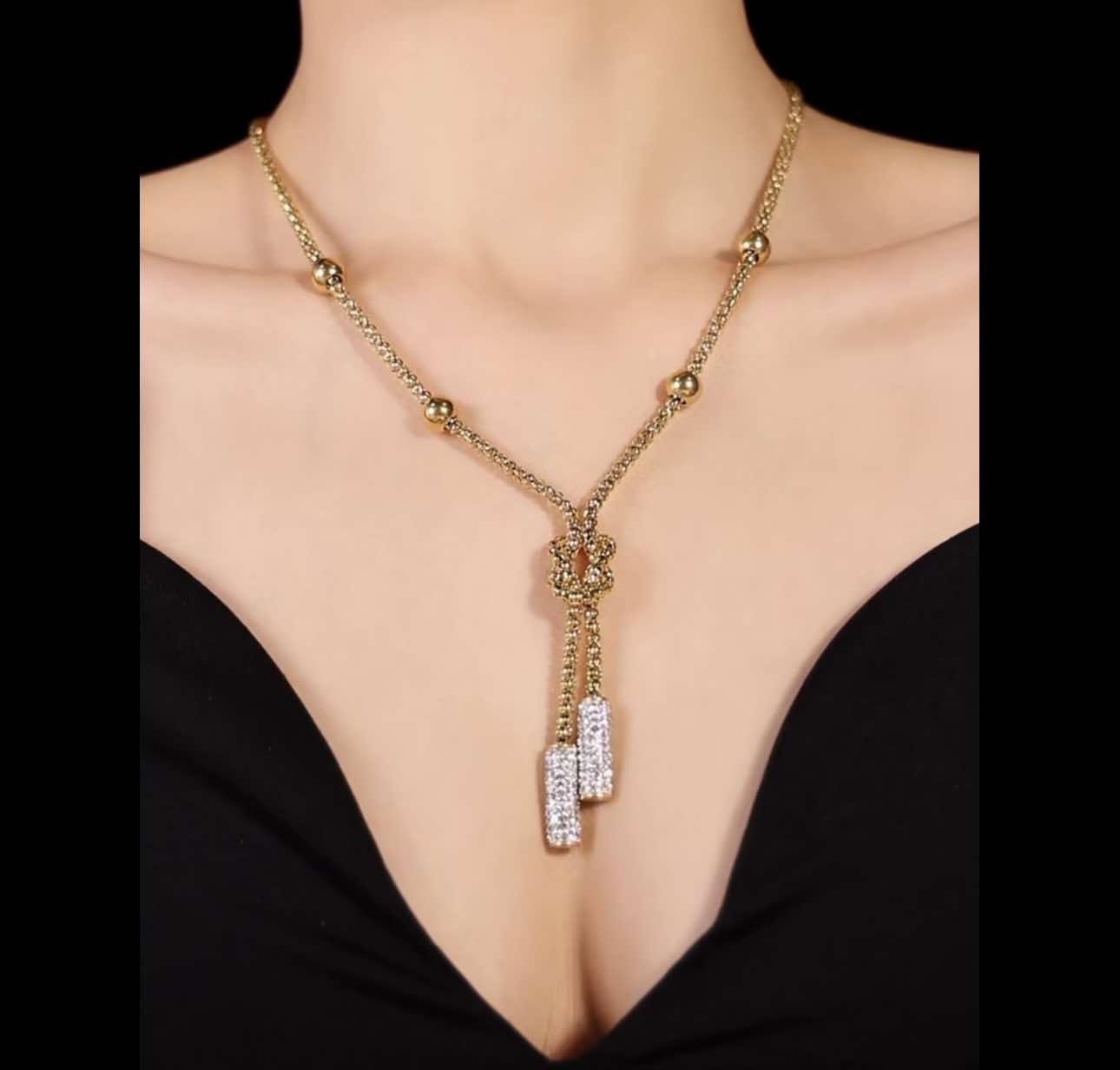 Close-up of Harper Drop Necklace pendant with sculptural knot and rhinestones.