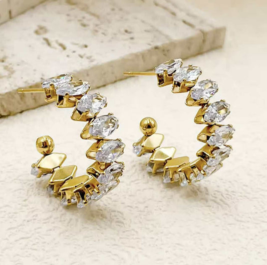 Gold zircon hoop earrings Close-up of 18k gold-plated hoop earring with clear zircon stones