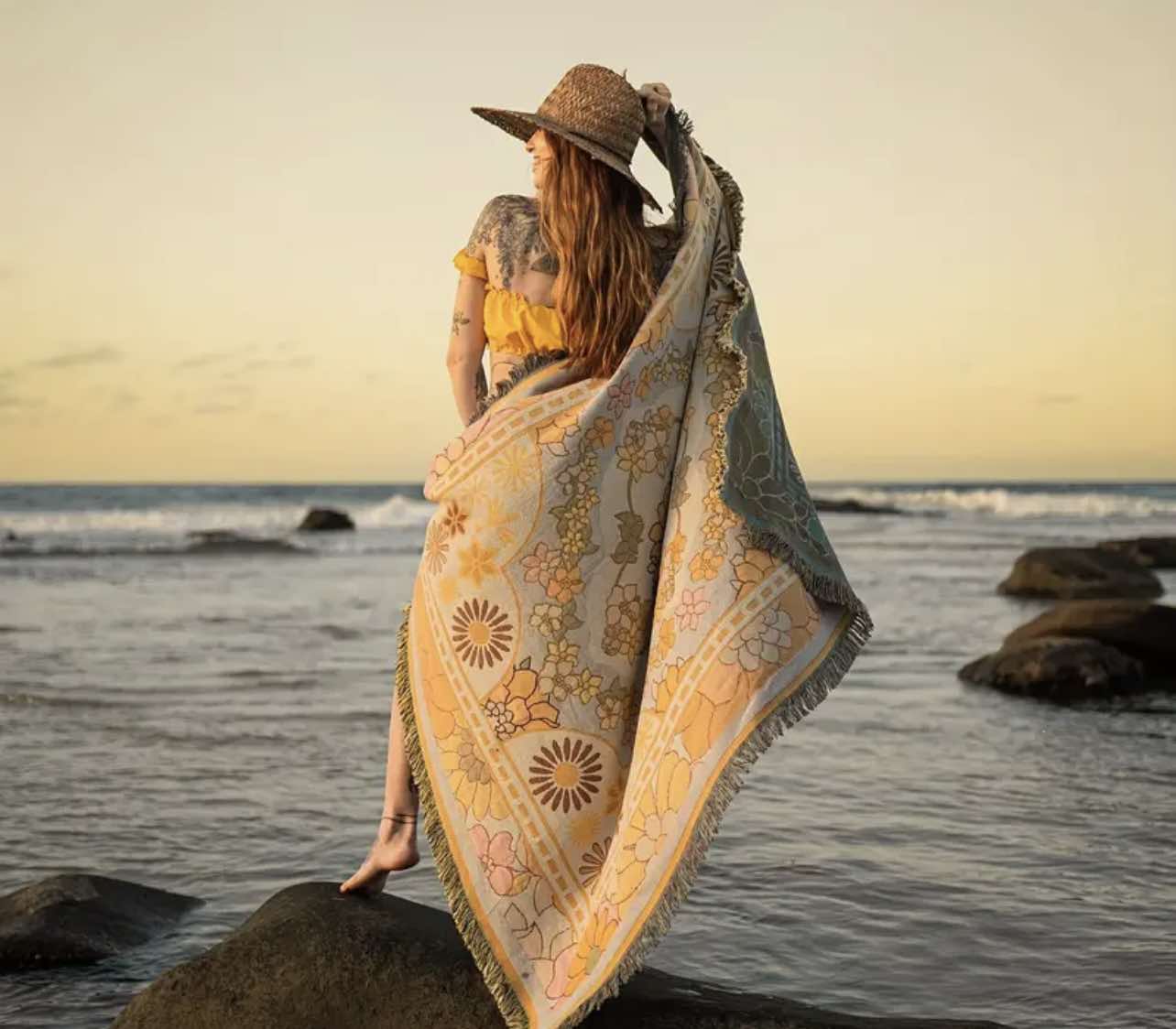 Golden Glow Boho Rug in use as a picnic blanket at the beach, combining boho elegance and outdoor functionality.