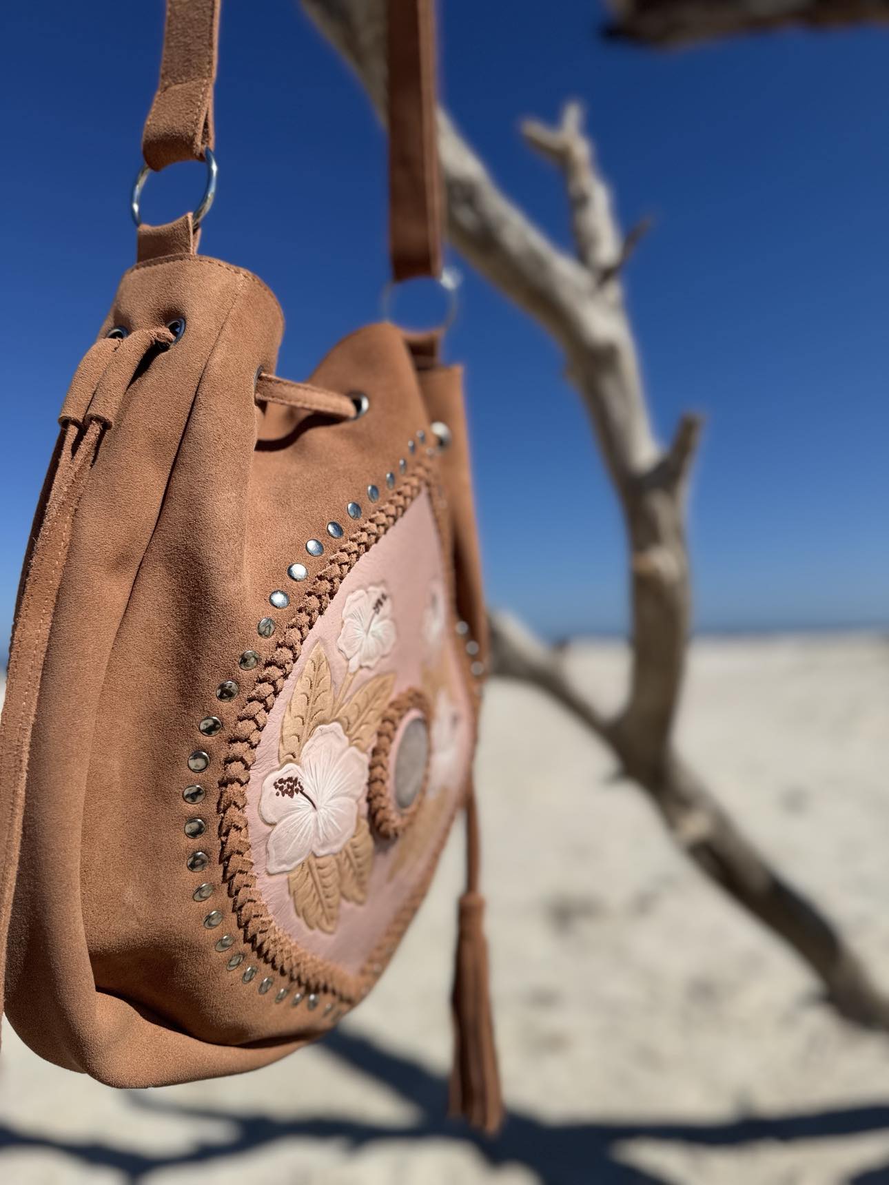 Hand-Painted Hibiscus Flower Western Suede Bag – Gorgeous blush-colored suede bag with hibiscus floral details and rose quartz, offering a chic and earthy western vibe.