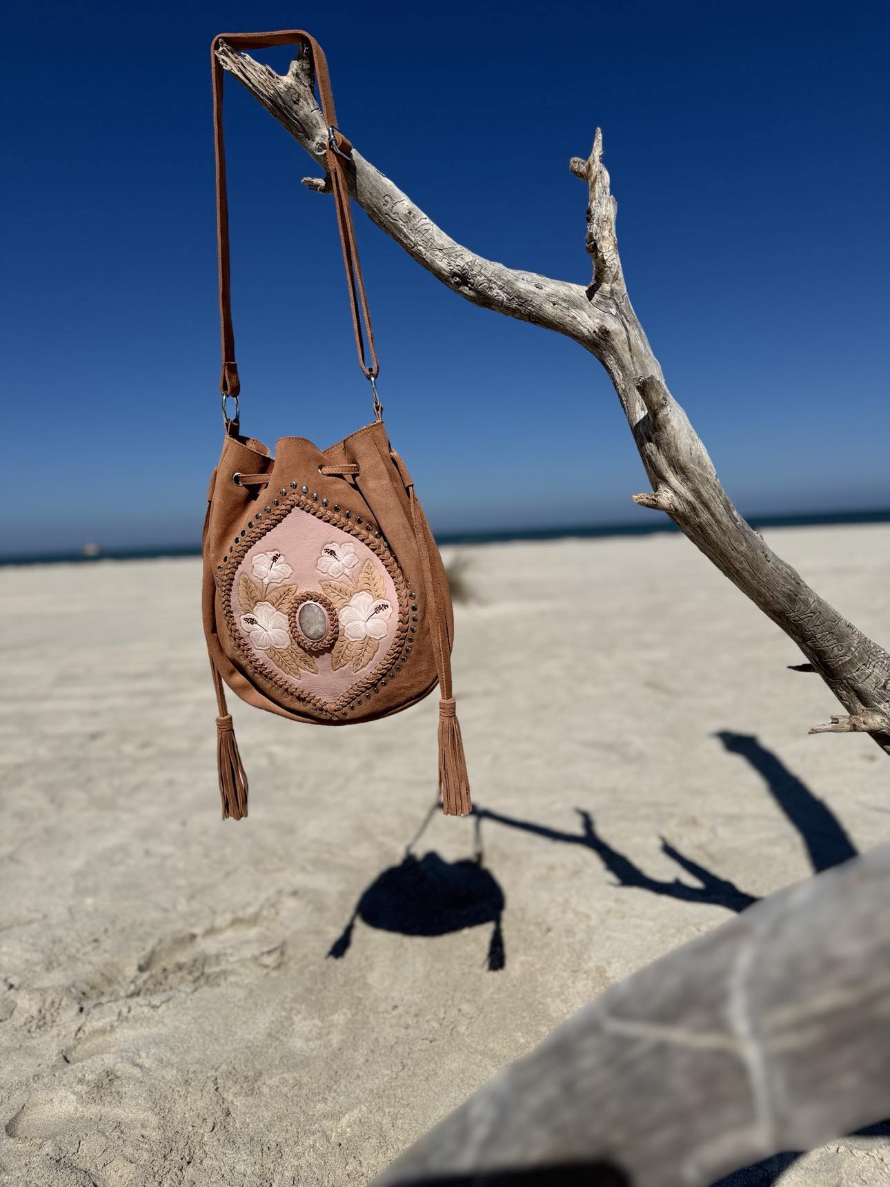 Rose Quartz and Hibiscus Hand-Painted Suede Bag – A western-inspired blush leather bag with beautiful hibiscus flower design and rose quartz gemstone for a sophisticated touch.