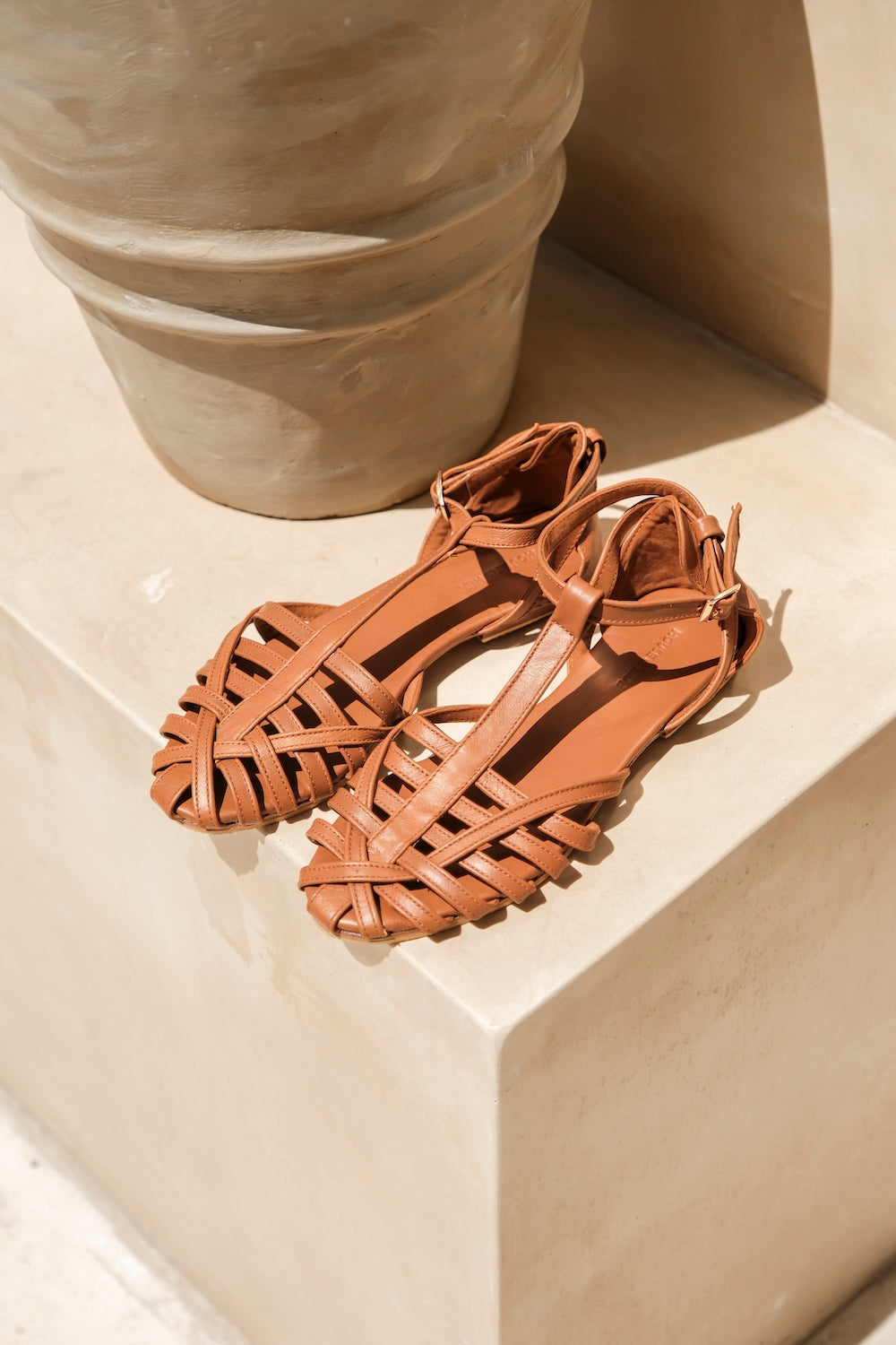 Handmade tan leather flats for women featuring breathable woven straps and supportive ankle slingback design