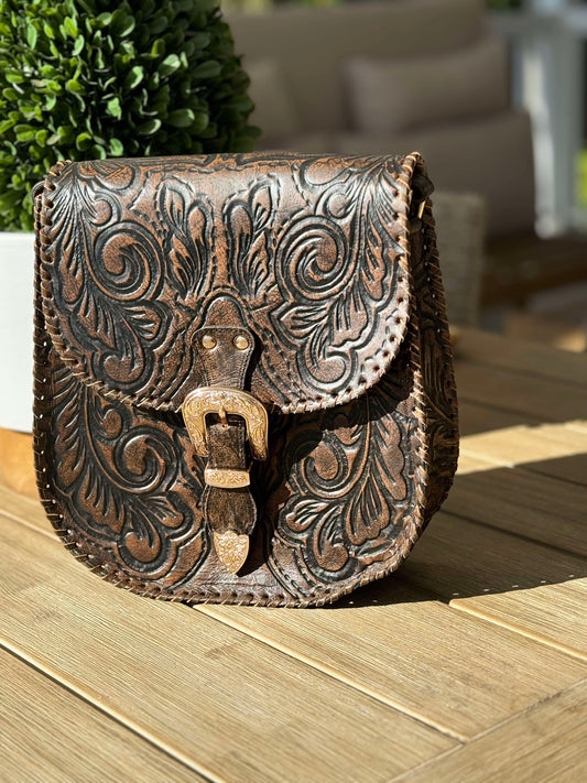 Indie Sky Hand-Tooled Leather Crossbody Bag in antique brown with adjustable strap and front magnetic closure. Made from soft genuine leather, featuring hand-tooled detailing.