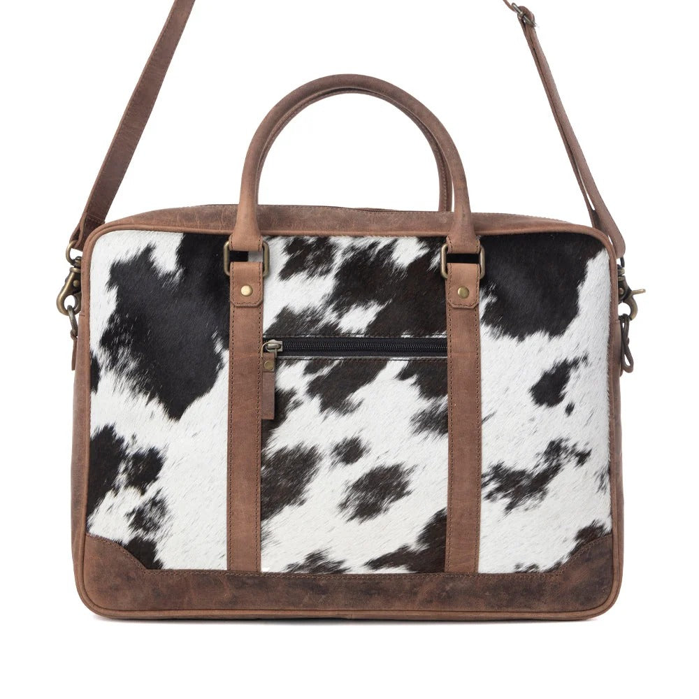 House of Hide genuine leather western handbag with a brown and white cow print design and brown leather trim on a white background