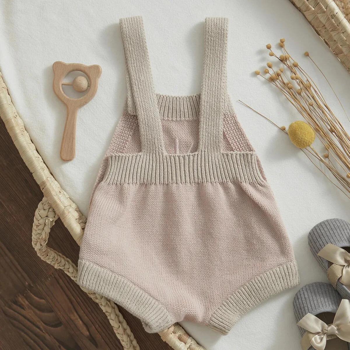 Soft pink romper for babies, showcasing a vibrant sun print and cozy ribbed knit material.