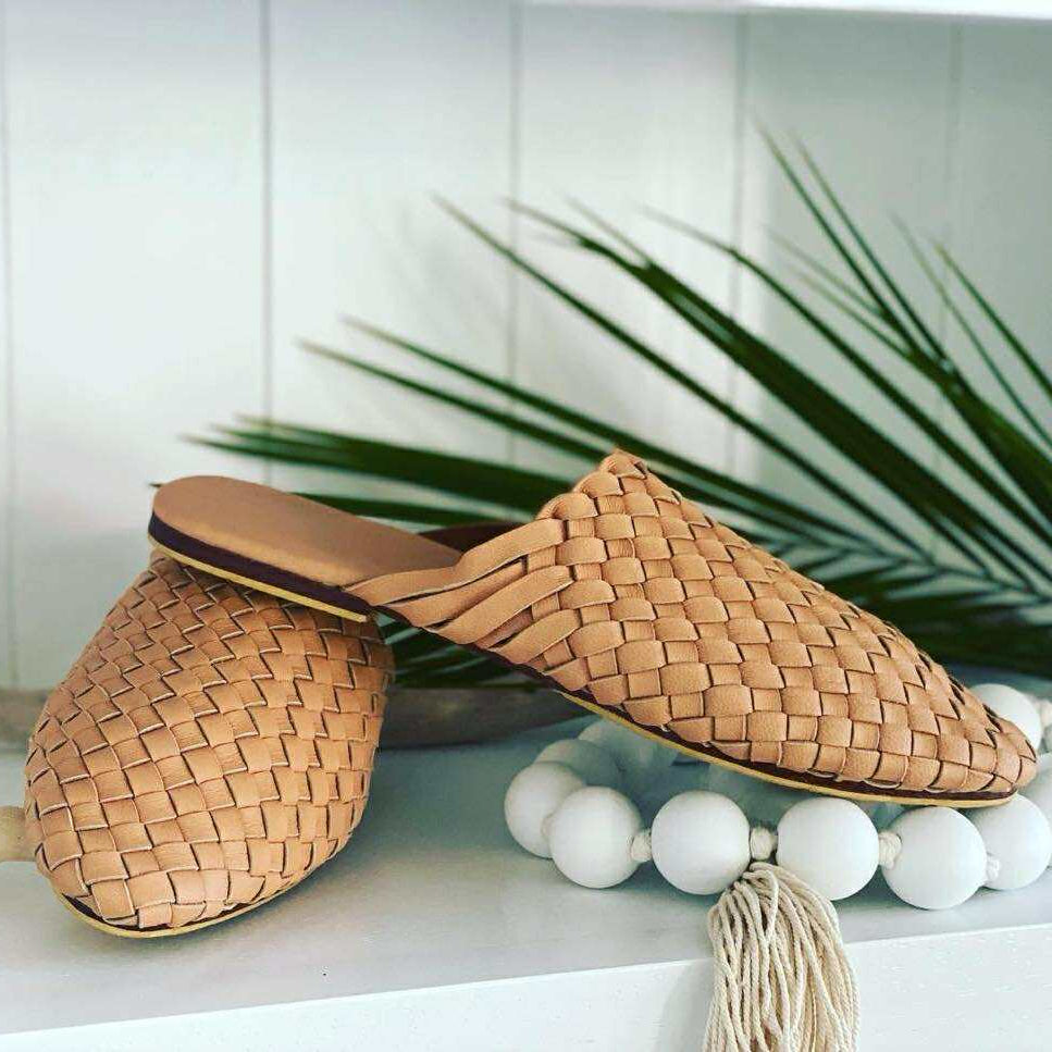 Woven sandals on a white surface with decorative elements