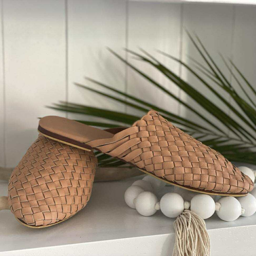 Pair of woven sandals on a shelf with decorative elements