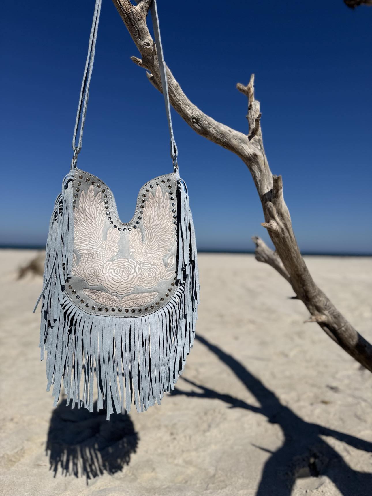 Light blue fringe handbag with tassels, perfect for cool summer skin tones and a boho-chic look.