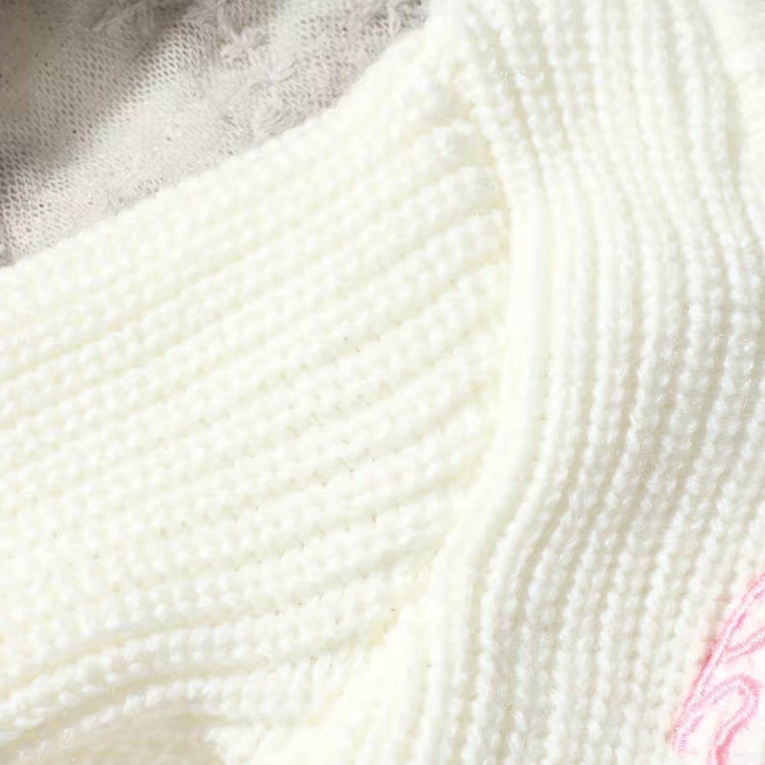 Little Wrangler Knit Romper Set from House of Hide in white ribbed knit with small pink embroidered detail being displayed in close-up