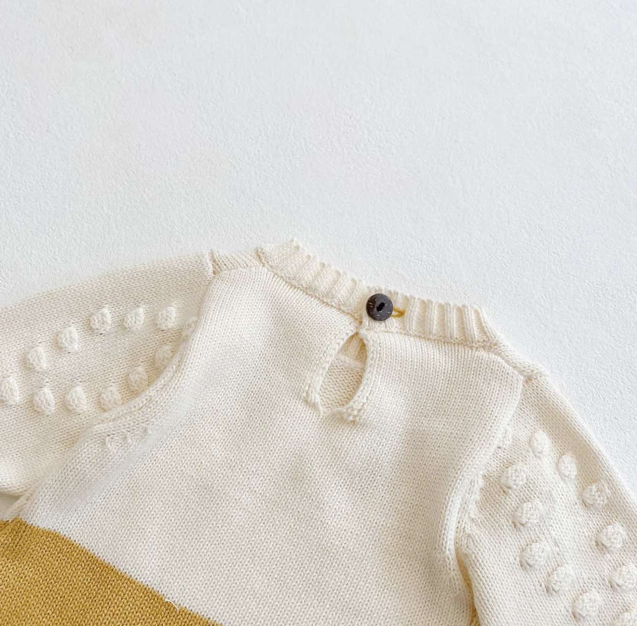 Long-sleeve baby romper with snap closures and sunflower design.