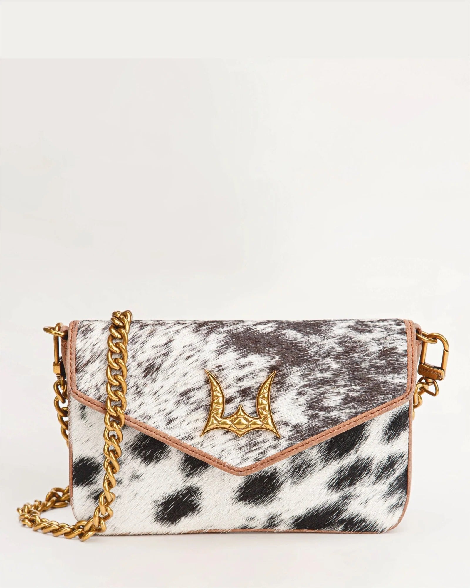 House of Hide genuine leather cow print handbag featuring a gold chain strap and clasp detail on a white background