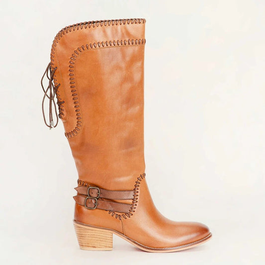 House of Hide genuine leather tan cowboy boot featuring decorative stitching, buckle details, and western-inspired craftsmanship on a light beige background