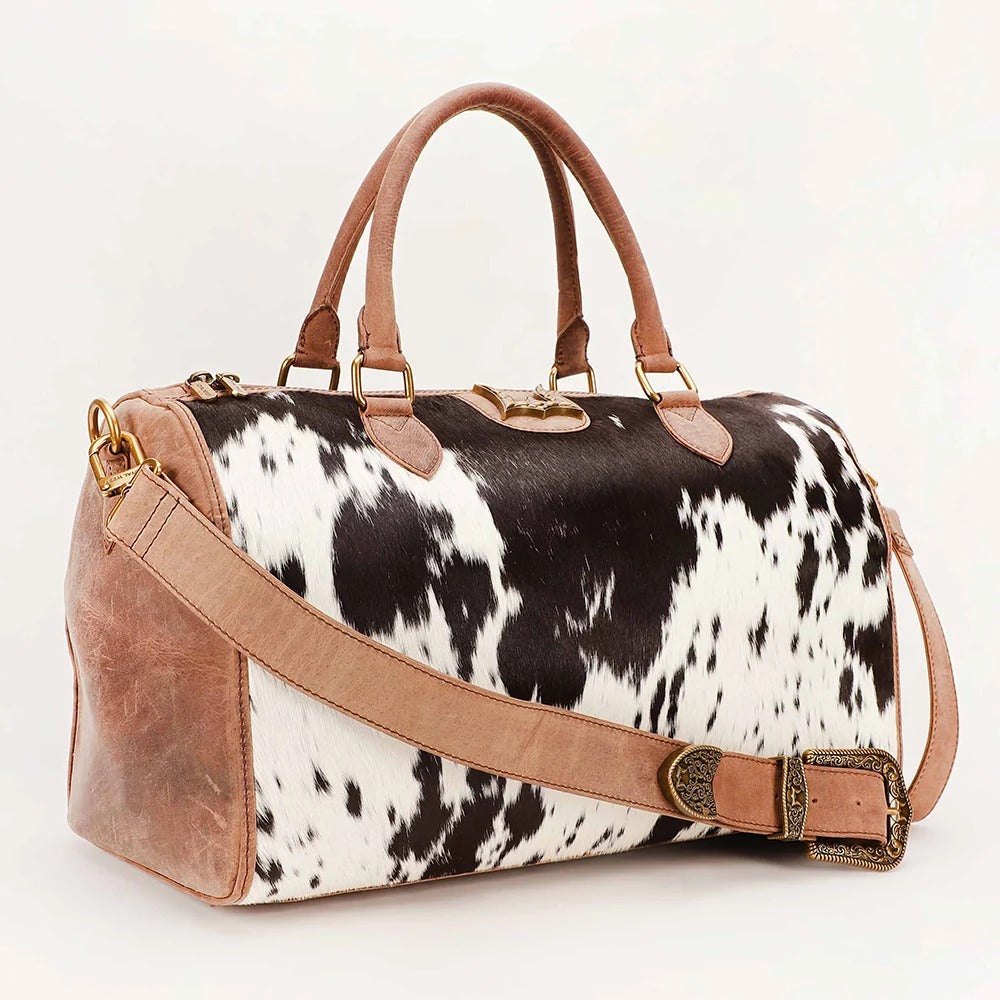 House of Hide genuine leather cow print duffel bag featuring brown leather accents and western-inspired craftsmanship on a white background