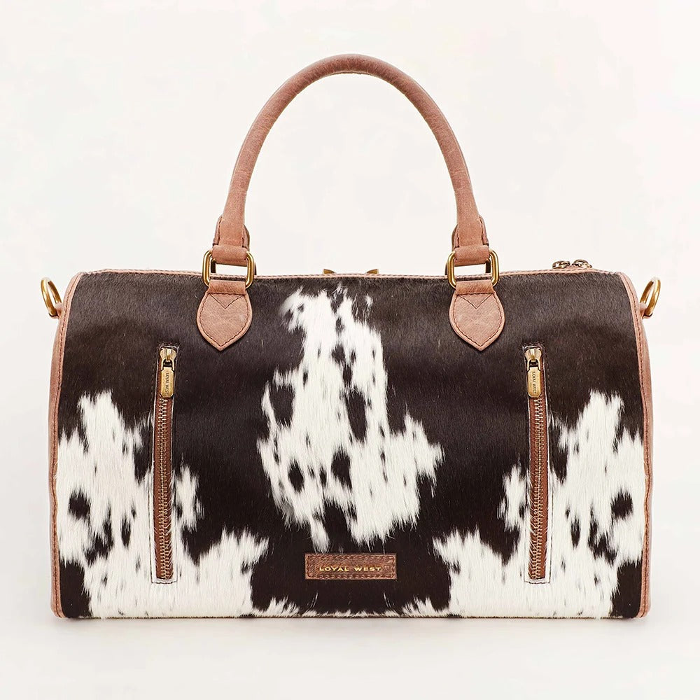 House of Hide genuine leather black and white cow print handbag featuring premium brown leather accents on a light beige background