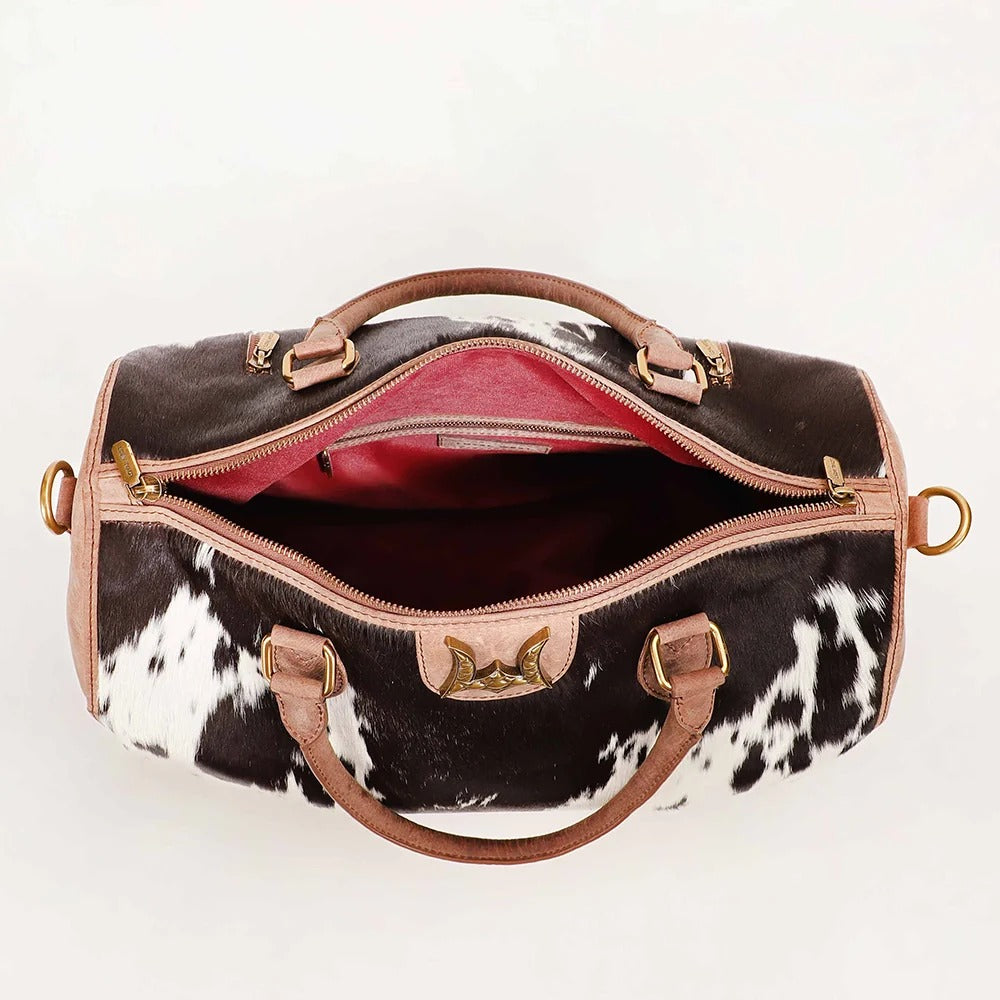 House of Hide genuine leather cow print duffel bag featuring elegant gold-tone accents and western-inspired design on a white background