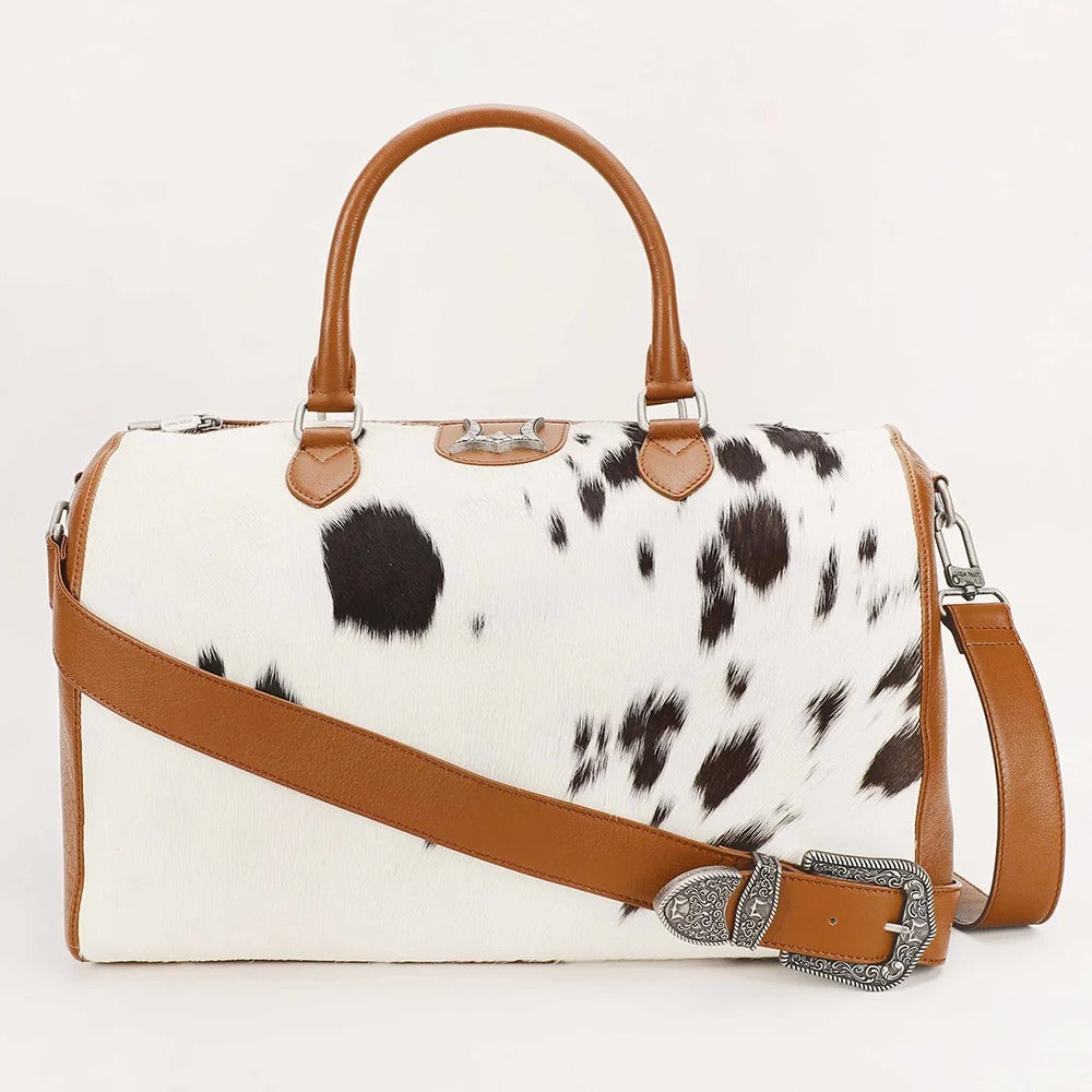 House of Hide genuine leather cow print handbag featuring brown leather straps and matching accents on a white background
