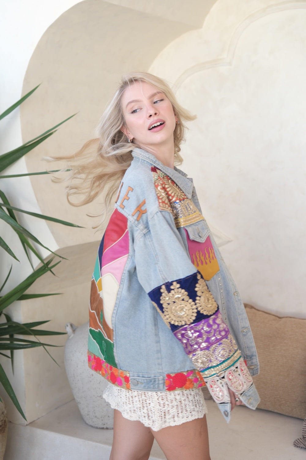 Model wearing embellished denim jacket styled with crochet dress – boho fashion for women Australia 