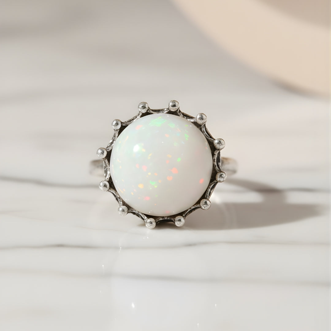 Elegant moonstone ring photographed on soft beige surface for House of Hide jewellery