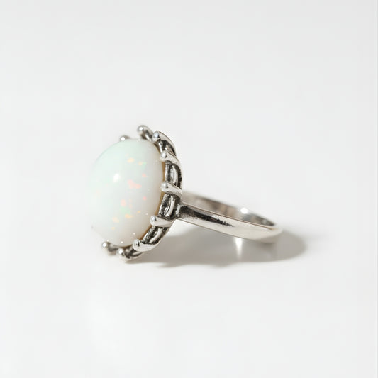 Moonstone Elegance Ring with luminous opal centerpiece on neutral beige backdrop