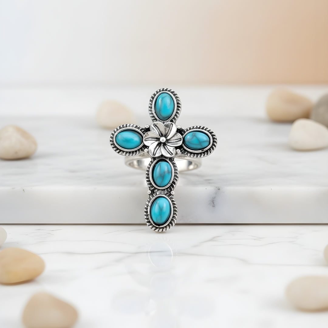 Ocean Bloom Cross Ring displayed on white surface elegant silver and turquoise design