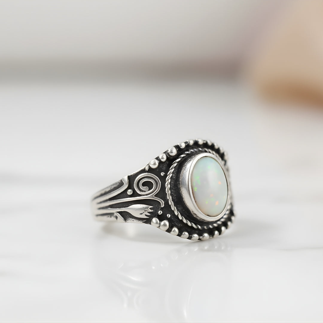 Pearl Reef Ring featuring luminous opal centerpiece and intricate silver band on white background