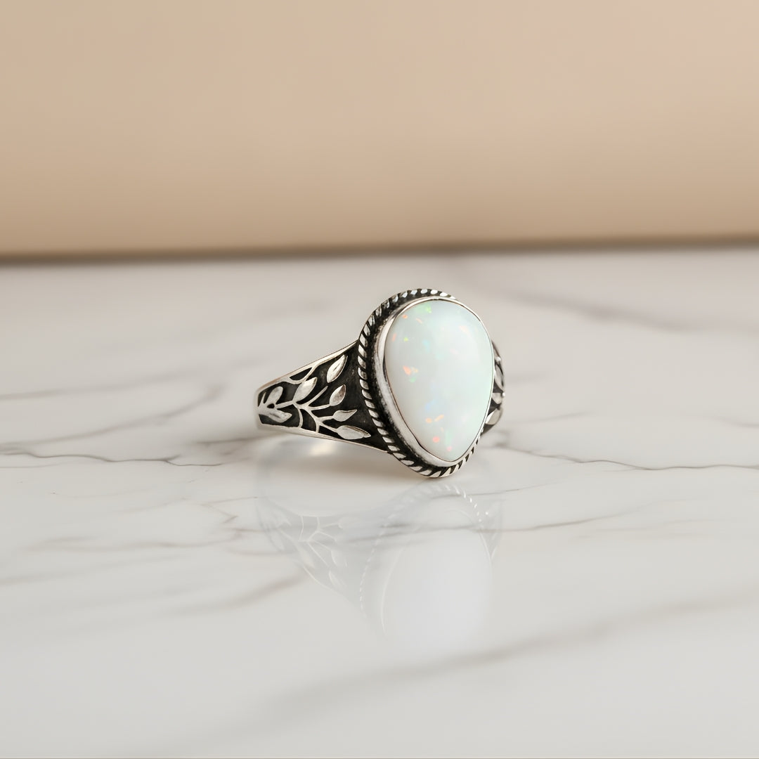 Elegant opal and leaf ring displayed on white surface from House of Hide jewellery Australia