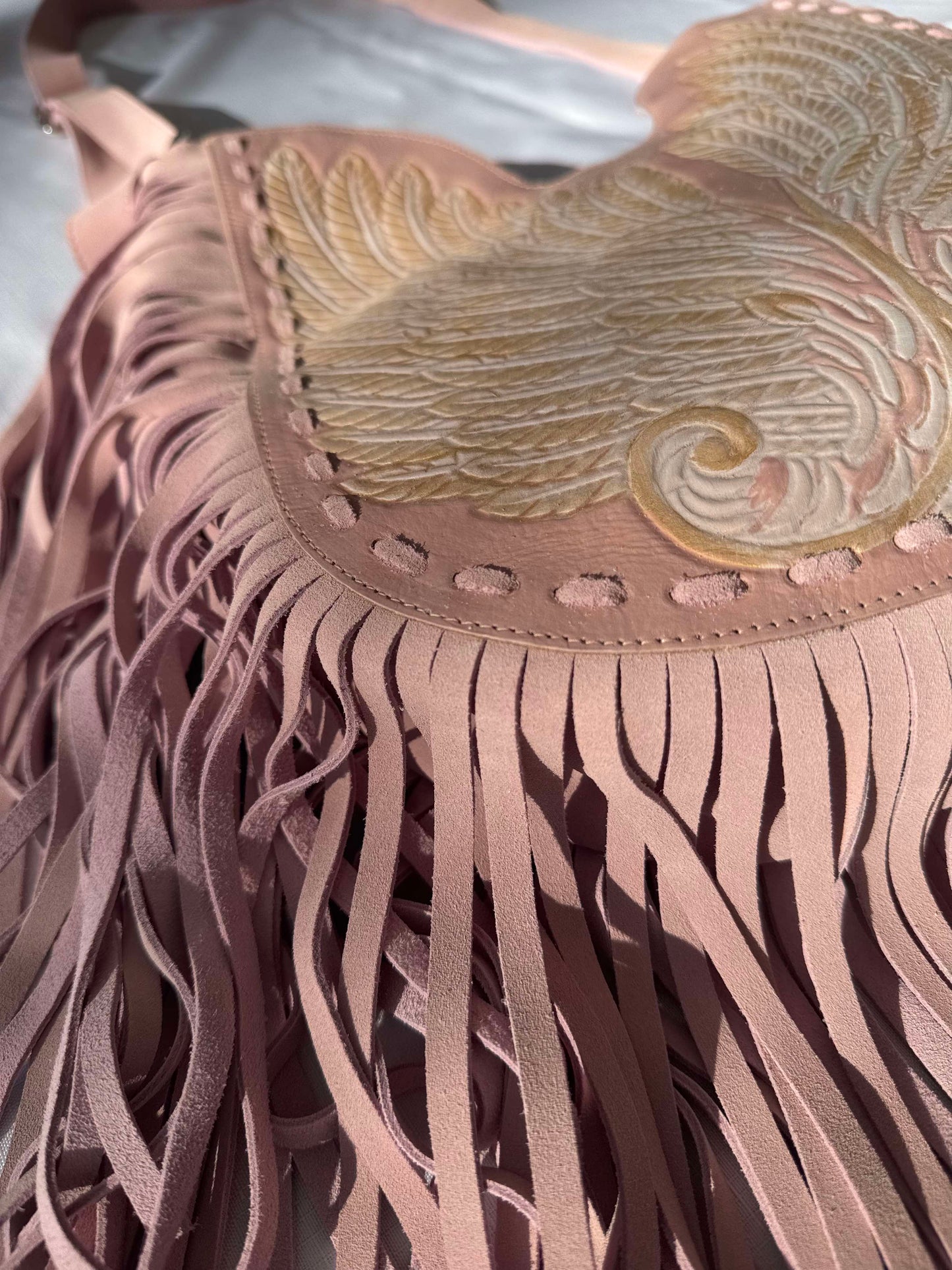Pink leather bag with fringe and wing embossing – perfect for boho summer style