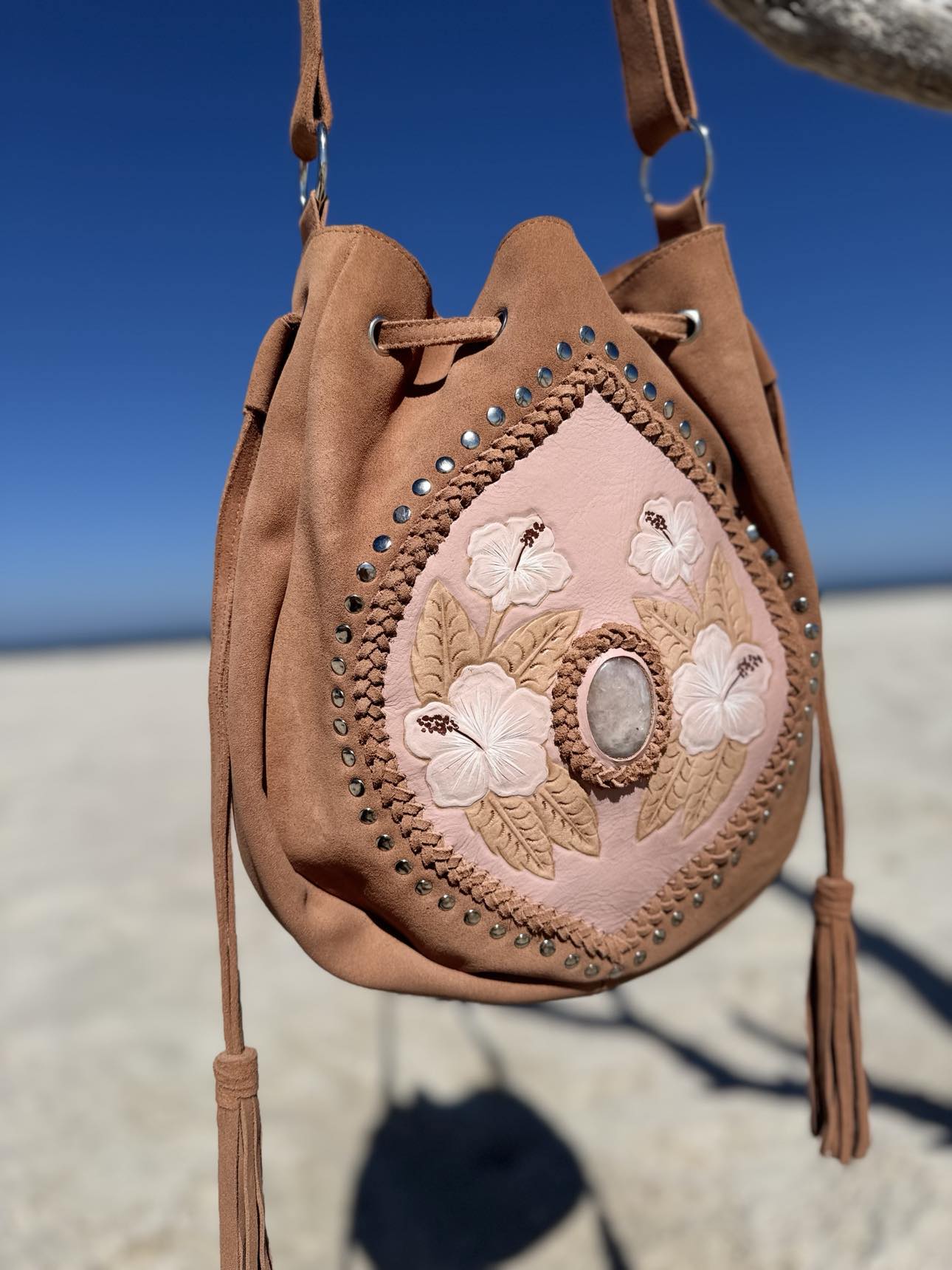 Rose Quartz and Hibiscus Hand-Painted Suede Bag – A western-inspired blush leather bag with beautiful hibiscus flower design and rose quartz gemstone for a sophisticated touch.