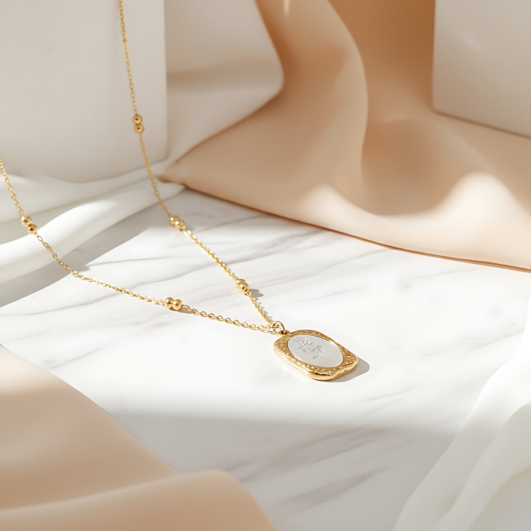 Roselle Pendant Necklace Perth House of Hide gold pendant with intricate floral design on gray background