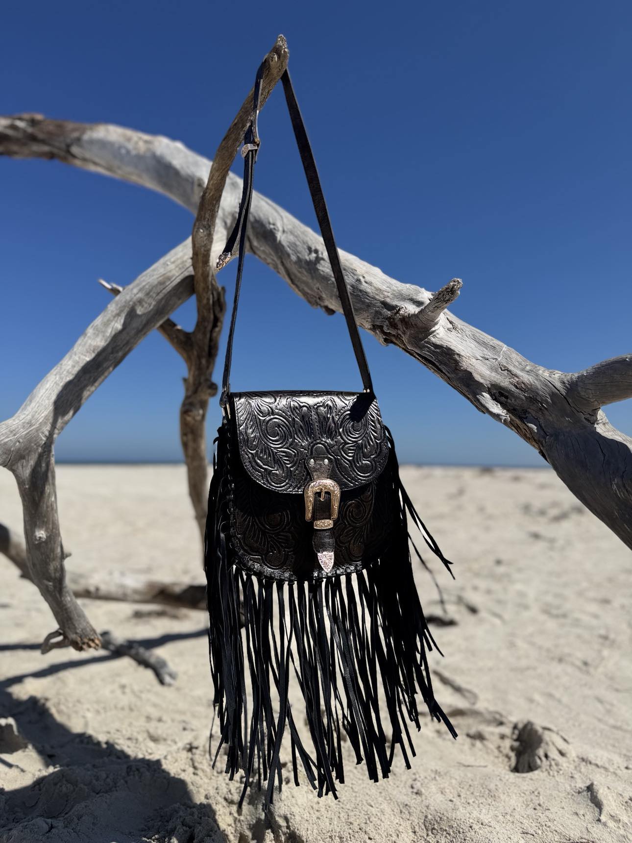 Side angle of the Blackstone Crossbody bag with black leather and elegant tassels, highlighting its western-inspired design.