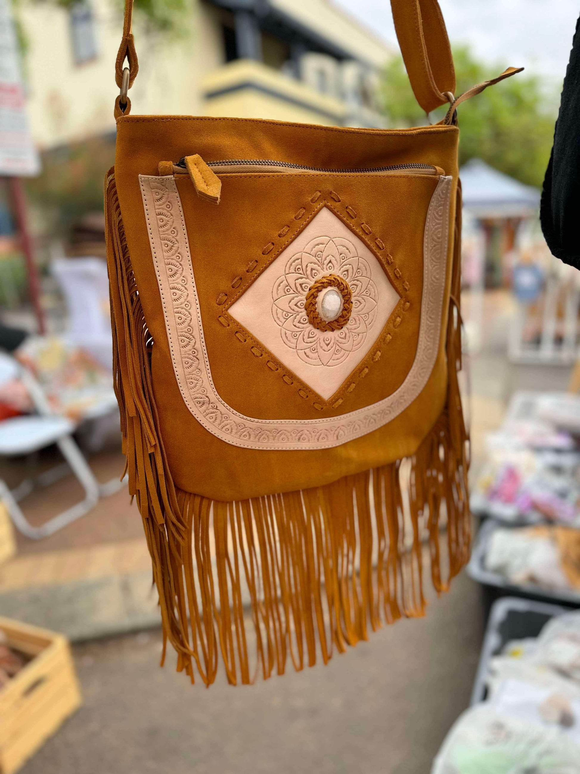 Side view of Sahara Spirit Suede Crossbody Bag showcasing its smooth brown suede, fringe detailing, and practical zippered back pocket