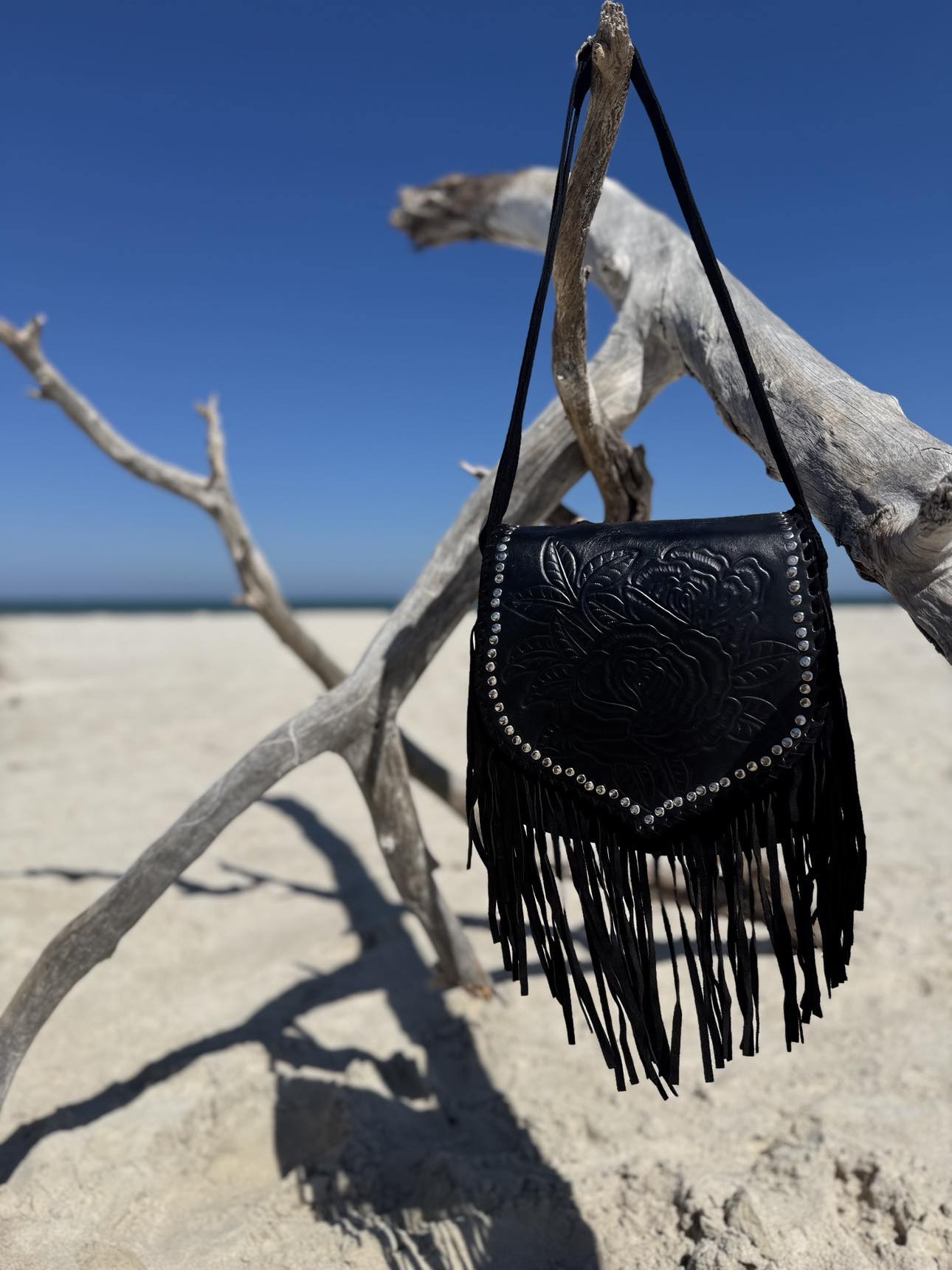 Side view of the Ebony Wild, featuring adjustable straps and detailed fringe for a bohemian western vibe.