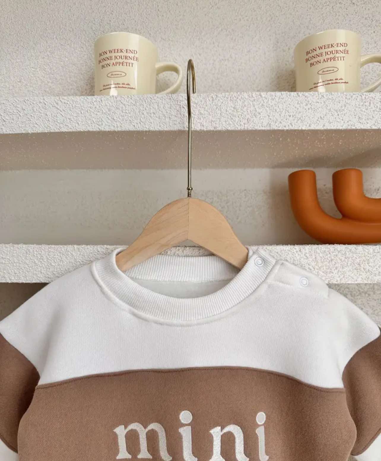 Side view of the trendy baby romper, emphasizing its slightly oversized fit and unisex design for all little ones.