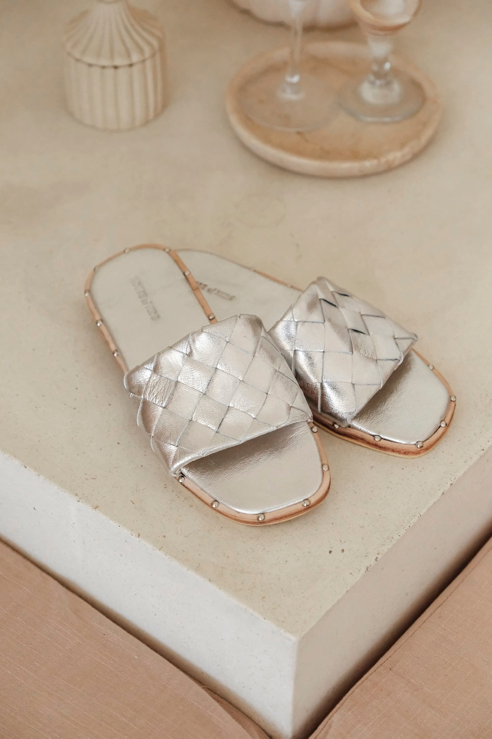 Close-up of silver woven leather slide sandal, Bottega Parco flat mule style dupe with soft leather weave and flat sole