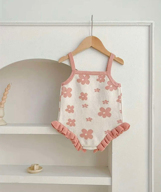 Size range display of floral knitted rompers in pink and beige, suitable for ages 3 months to 3 years.