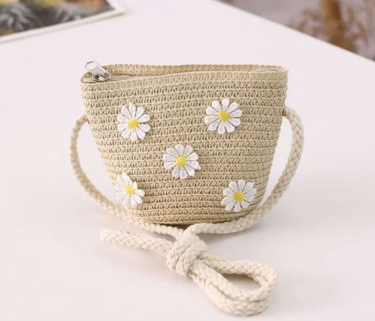 Small crossbody bag for children featuring a daisy pattern and zip closure.