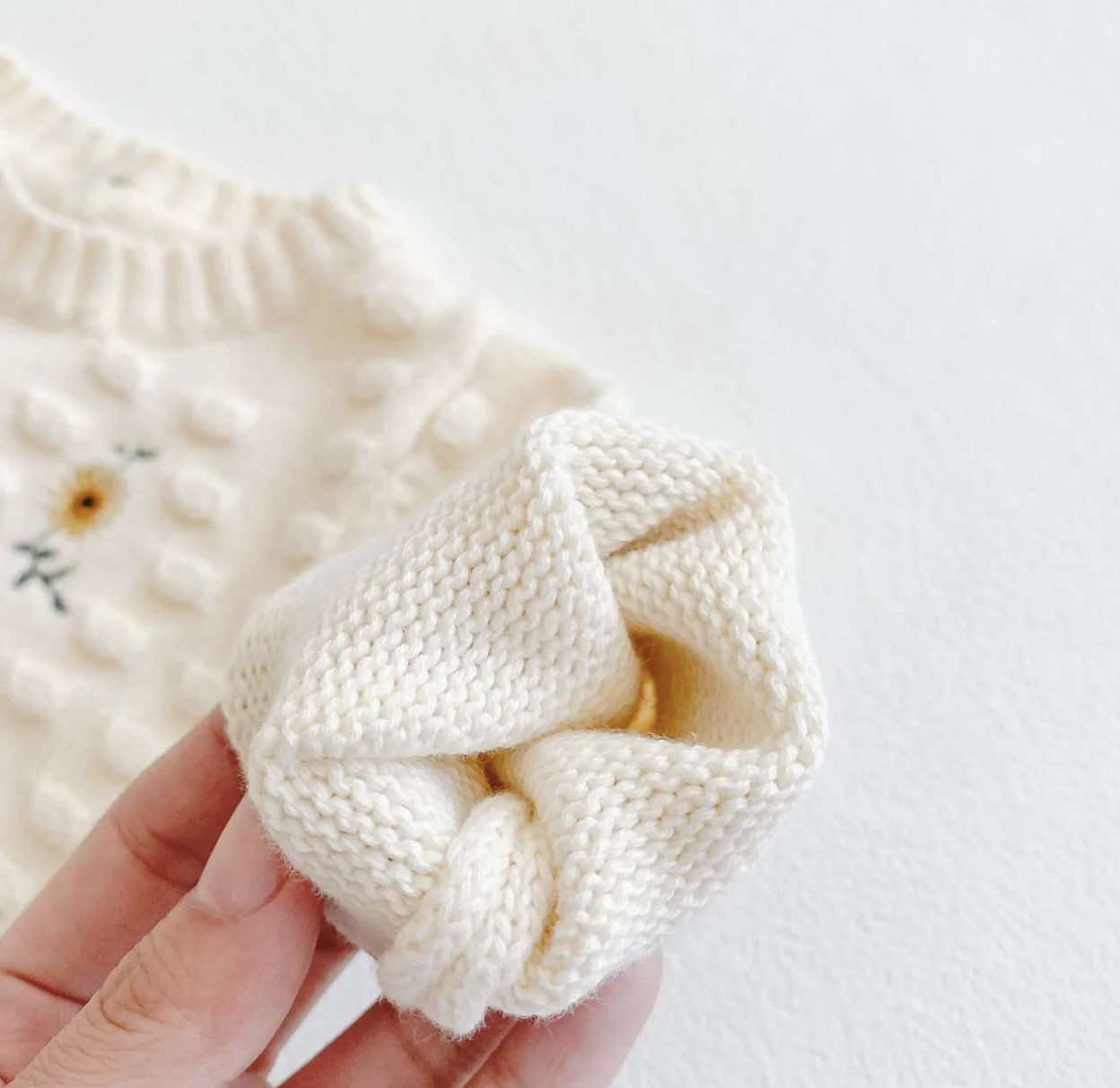 Soft crochet baby romper in cozy fall colors, perfect for winter wear.