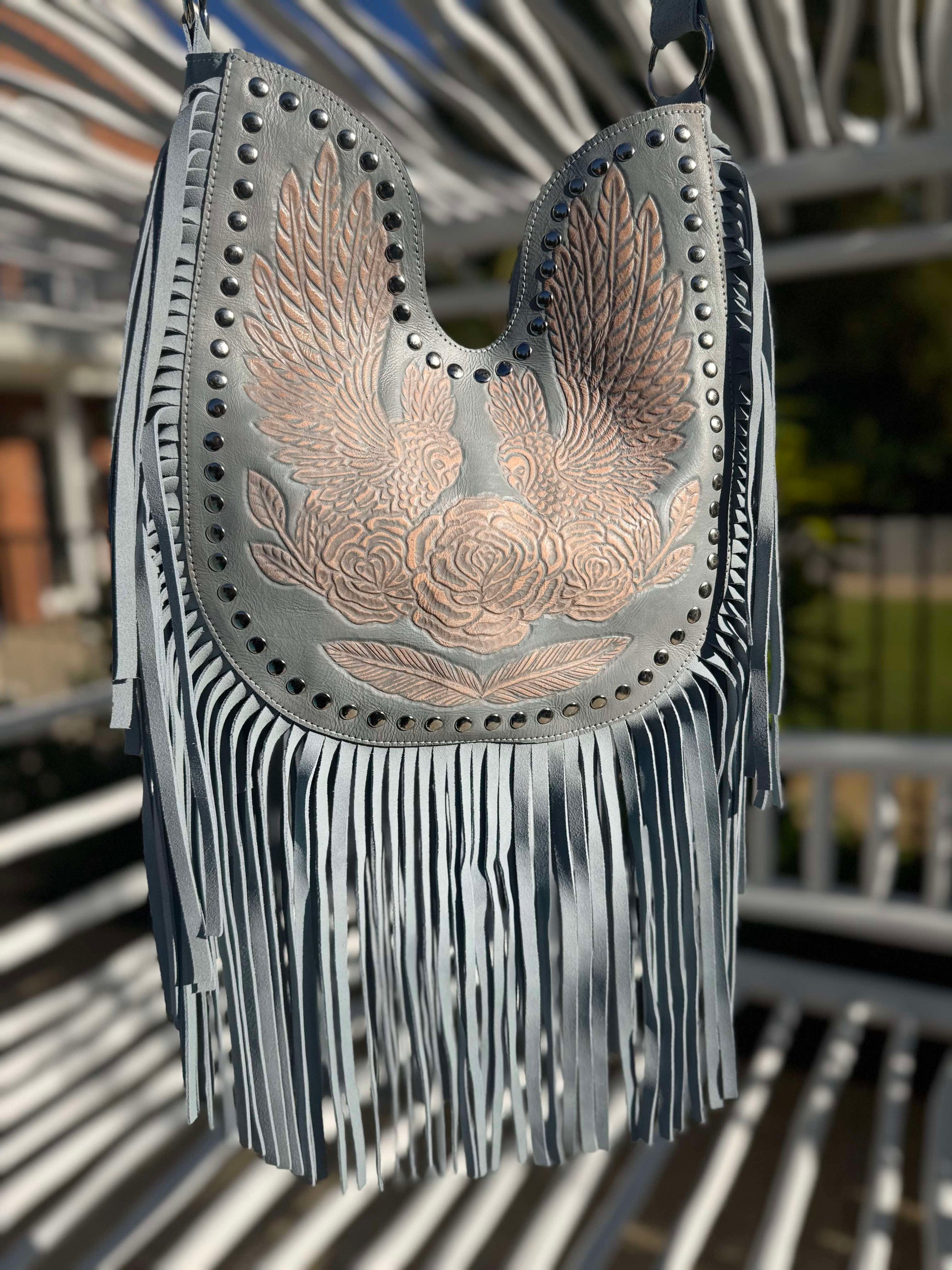 Soft suede crossbody bag in bluewith long fringe and wing design