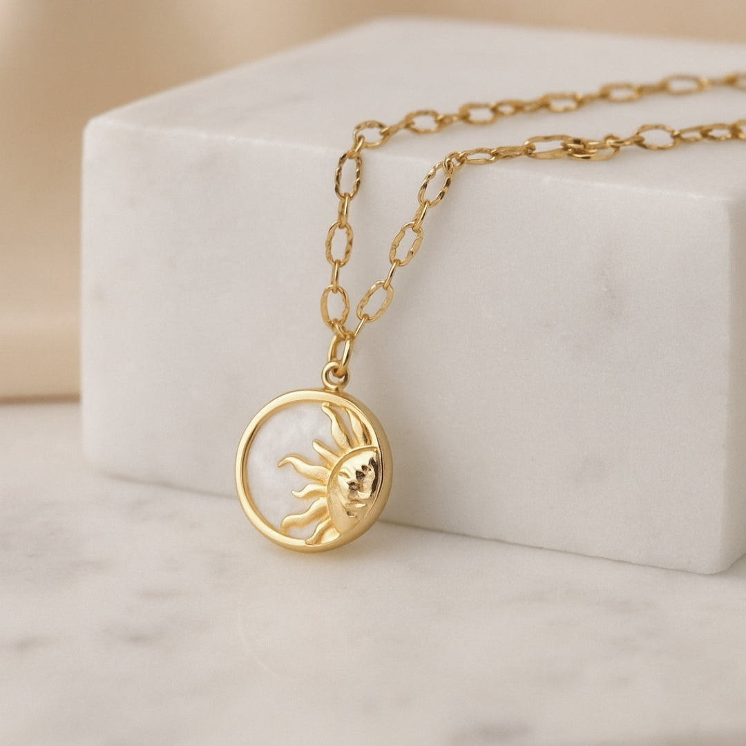 Sol Pendant Necklace displayed on white surface elegant gold chain with sun clasp