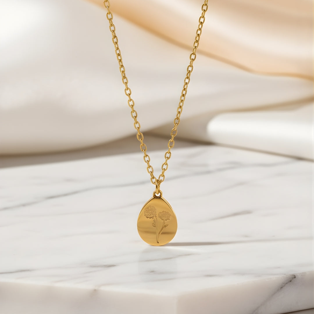 Solenne Pendant Necklace featuring delicate gold chain with small charm on gray surface