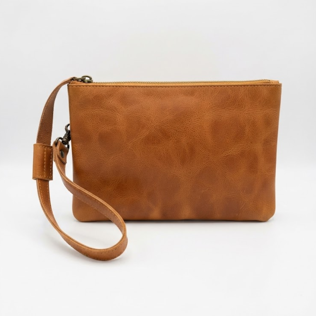 A rectangular tan leather wristlet clutch with a matching wrist strap and a top zipper closure, shown on a plain white background.