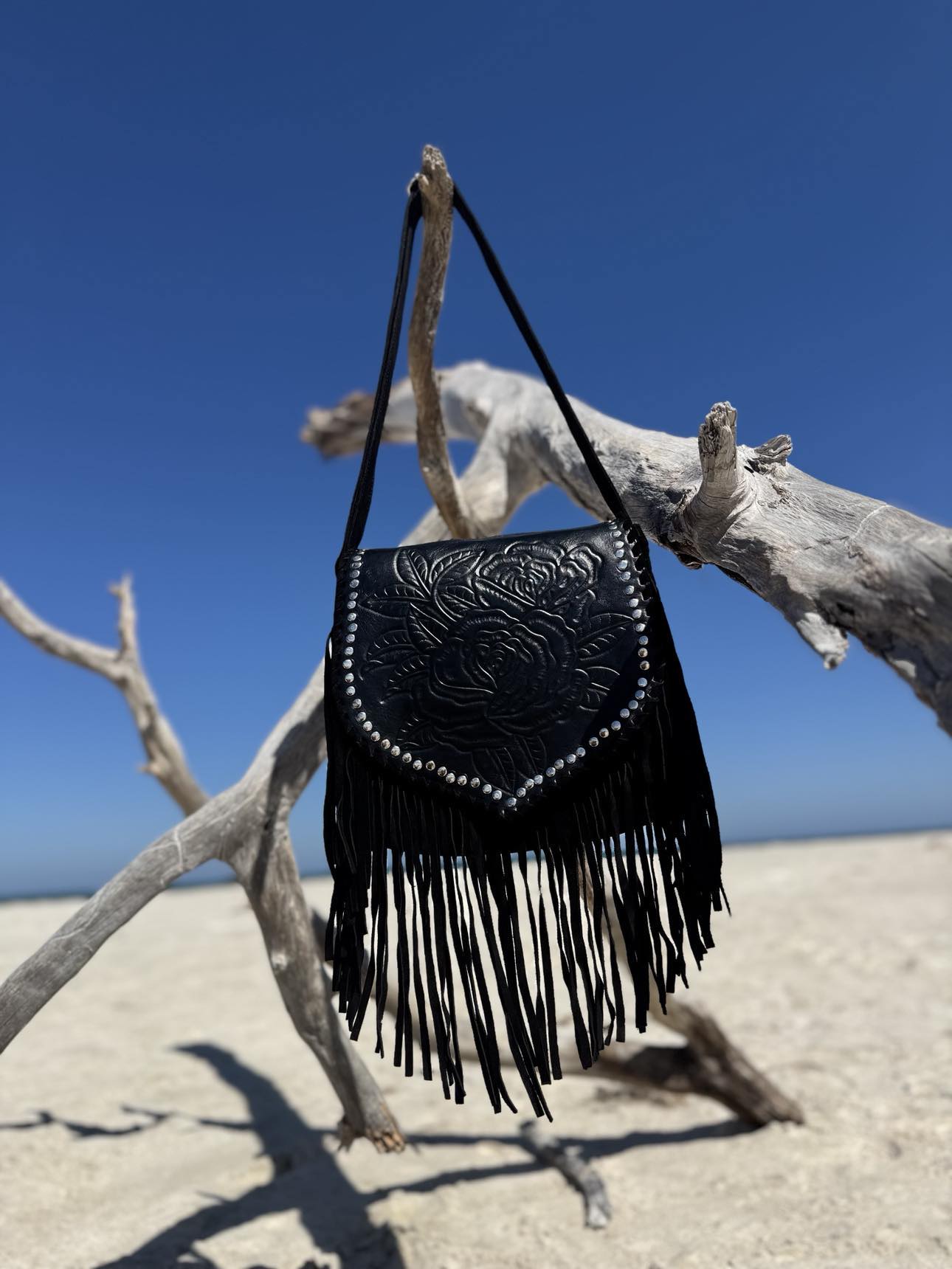 Stylish black leather bag with tassels, showcasing vintage black design and boho fringe details.