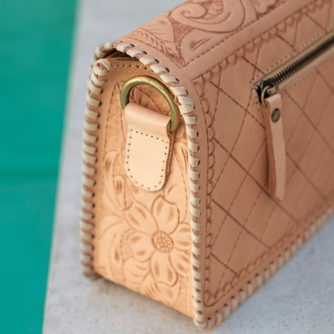 Sunset Saddle Clutch Bag from House of Hide in tan leather showing floral tooling, whipstitched edges, gold-tone ring and zipper detail