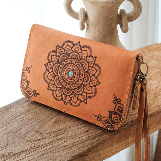 House of Hide Talisman Wallet in tan leather with turquoise center mandala design being displayed on rustic wooden surface