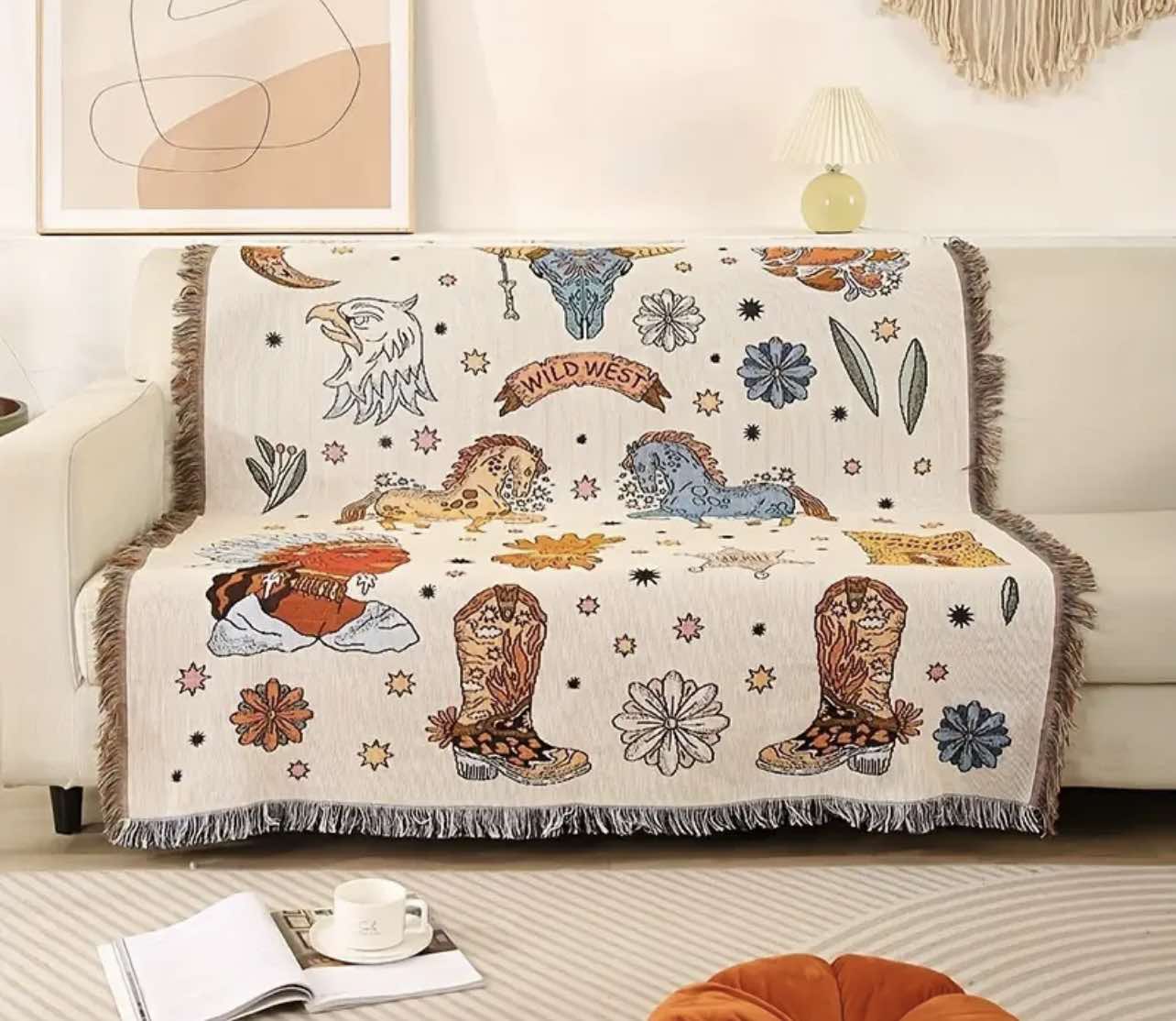 The Western Rodeo Jacquard Woven Throw Blanket draped over a sofa, showcasing its bold cowboy patterns and tassels.