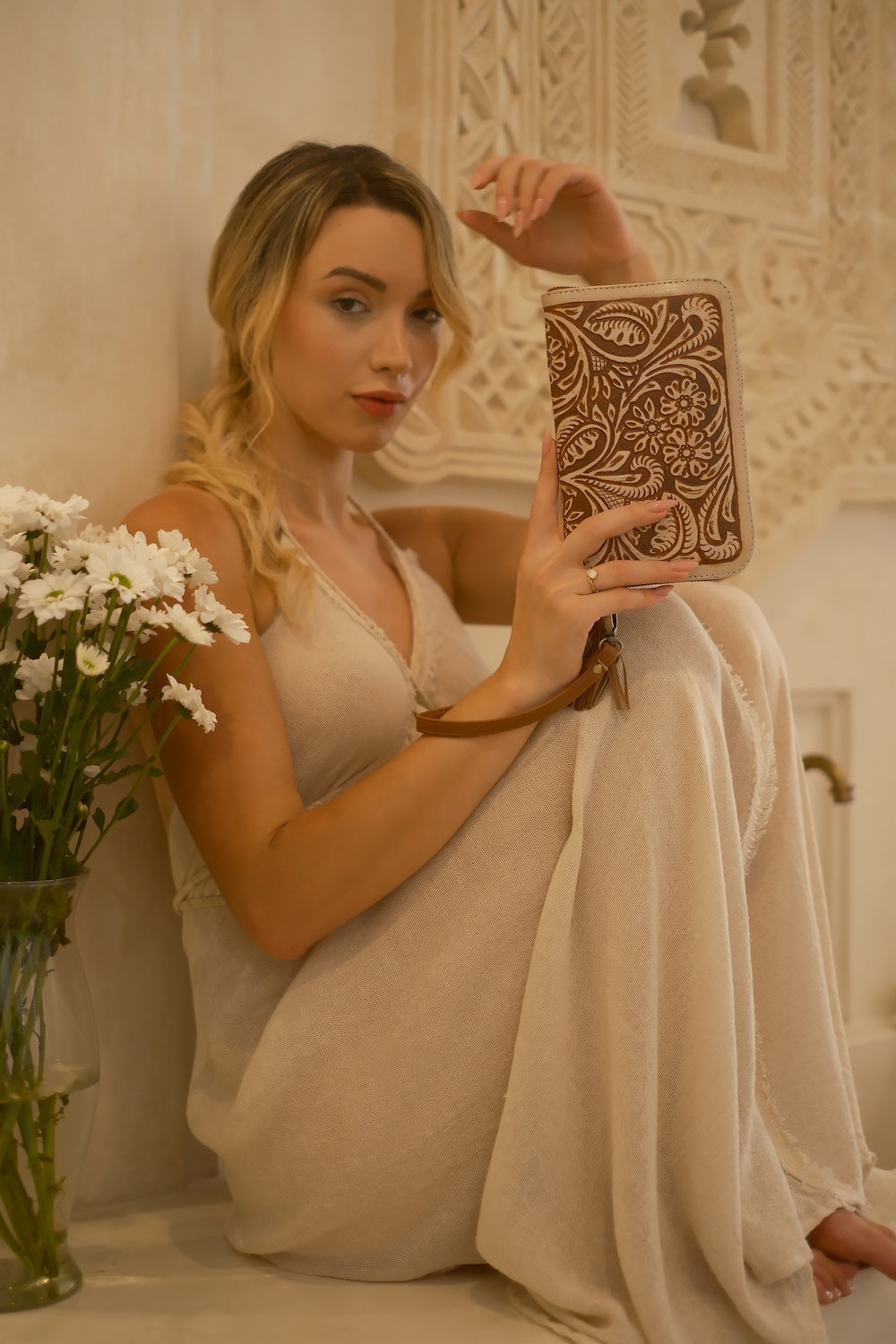 Two‑tone leather clutch wallet with intricate carving, stone detail, 20 card slots, and secure zip fastening.